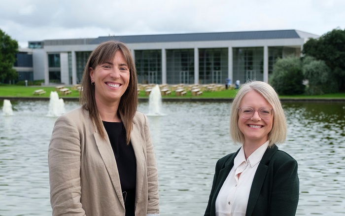A photo of Fiona Freeman and Jennifer Keating beside the UCD Lake opposite O'Reilly Hall